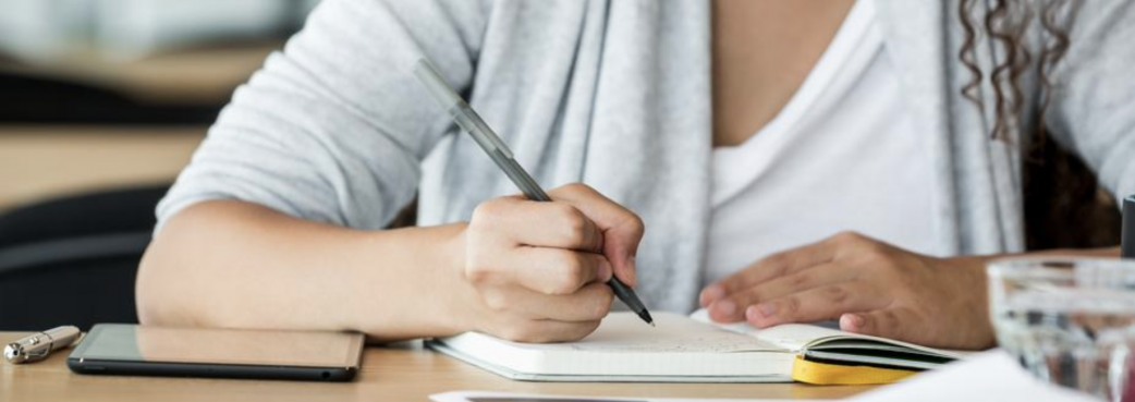 Faceless young female writing.png